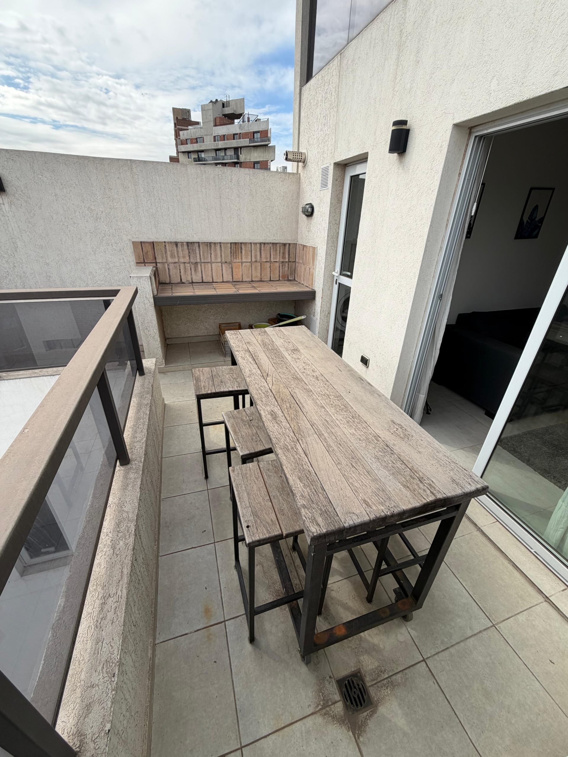 Departamento dúplex en venta de 1 dormitorio sobre calle Ambrosio Olmos 836 vista asador y mesa de madera